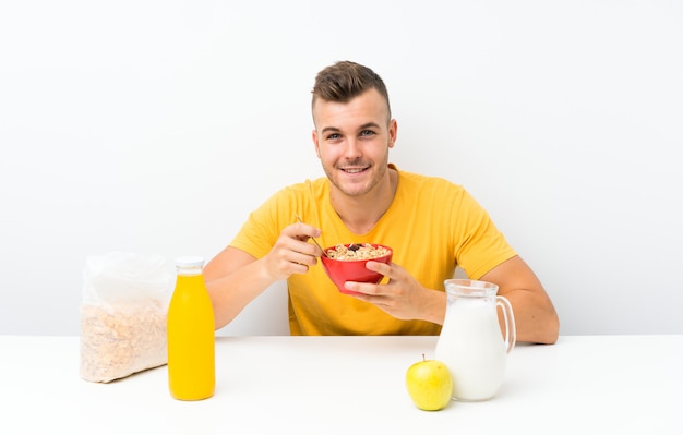 Giovane uomo biondo che mangia prima colazione