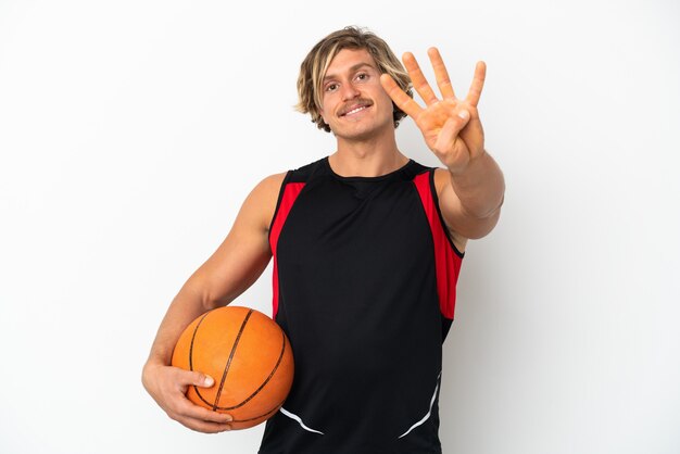 Giovane uomo biondo che tiene una palla di basket isolata on white felice e contando quattro con le dita