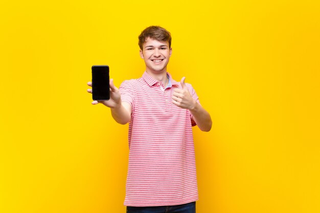 Giovane uomo biondo con un cellulare smartphone