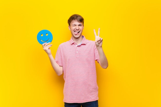 Giovane uomo biondo con un'icona del viso sorridente