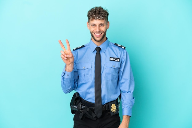 Giovane uomo biondo della polizia isolato bianco su sfondo blu sorridente e mostrando il segno della vittoria