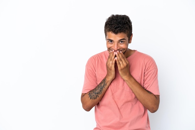 Giovane uomo brasiliano bello isolato su sfondo bianco felice e sorridente che copre la bocca con le mani