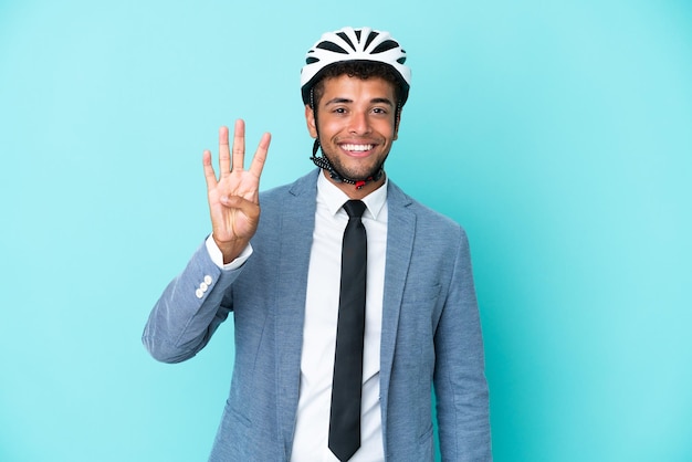 Giovane uomo brasiliano d'affari con casco da bici isolato su sfondo blu felice e contando quattro con le dita