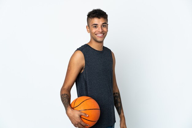 Giovane uomo brasiliano su sfondo isolato giocando a basket