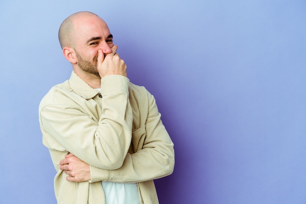 Giovane uomo calvo caucasico isolato su sfondo viola che ride felice, spensierata, emozione naturale.