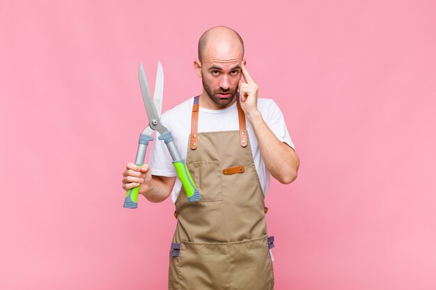 Giovane uomo calvo che sembra sorpreso, a bocca aperta, scioccato, realizzando un nuovo pensiero, idea o concetto