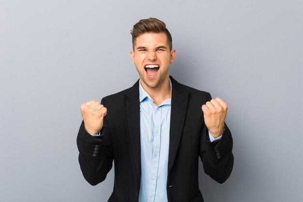 Giovane uomo caucasico bello che incoraggia spensierato ed eccitato. Concetto di vittoria.