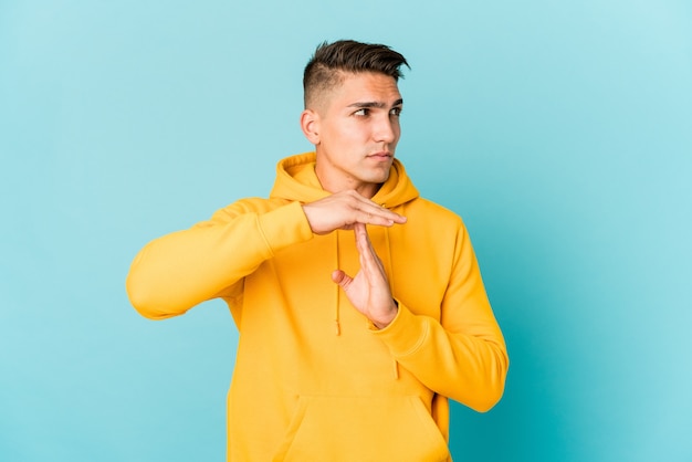 Giovane uomo caucasico bello isolato che mostra un gesto di timeout.