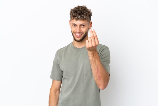 Giovane uomo caucasico bello isolato su sfondo bianco che fa gesto di denaro