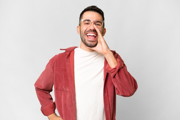 Giovane uomo caucasico bello isolato su sfondo bianco gridando con la bocca spalancata