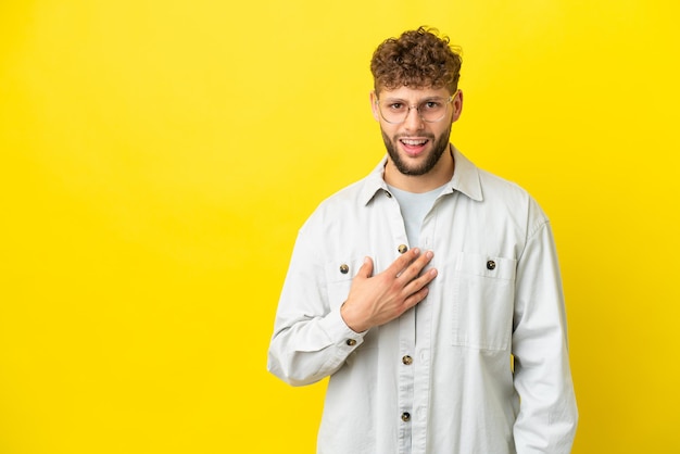 Giovane uomo caucasico bello isolato su sfondo giallo che punta a se stesso