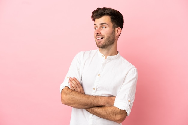 Giovane uomo caucasico bello isolato su sfondo rosa felice e sorridente