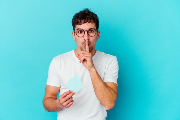 Giovane uomo caucasico che celebra la giornata mondiale dell'acqua isolato mantenendo un segreto o chiedendo il silenzio.