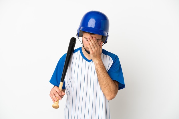 Giovane uomo caucasico che gioca a baseball isolato su sfondo bianco con espressione stanca e malata