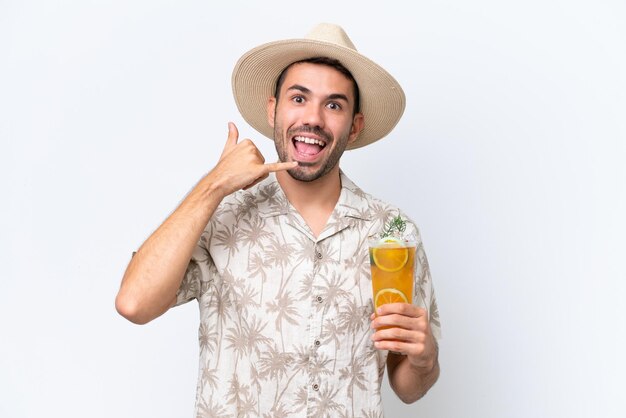 Giovane uomo caucasico che tiene un cocktail isolato su sfondo bianco che fa il gesto del telefono Call me back sign