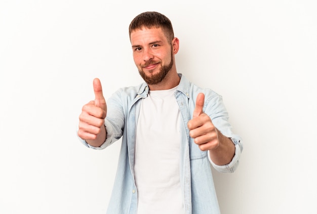 Giovane uomo caucasico con diastema isolato su sfondo bianco alzando entrambi i pollici, sorridente e fiducioso.