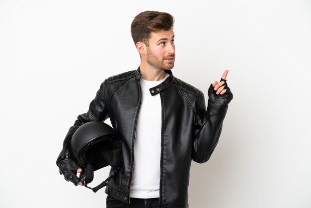 Giovane uomo caucasico con un casco da motociclista isolato su sfondo bianco che indica una grande idea
