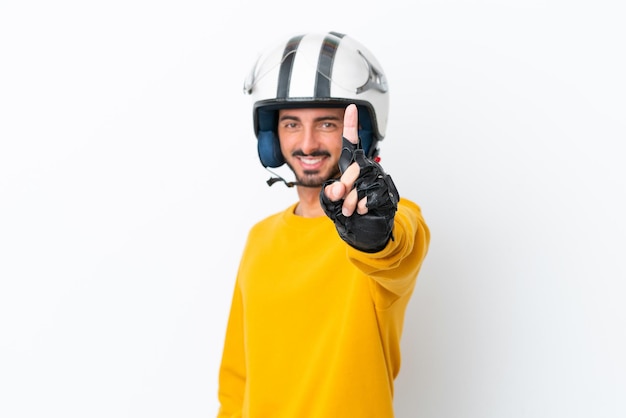 Giovane uomo caucasico con un casco da motociclista isolato su sfondo bianco che mostra e alza un dito