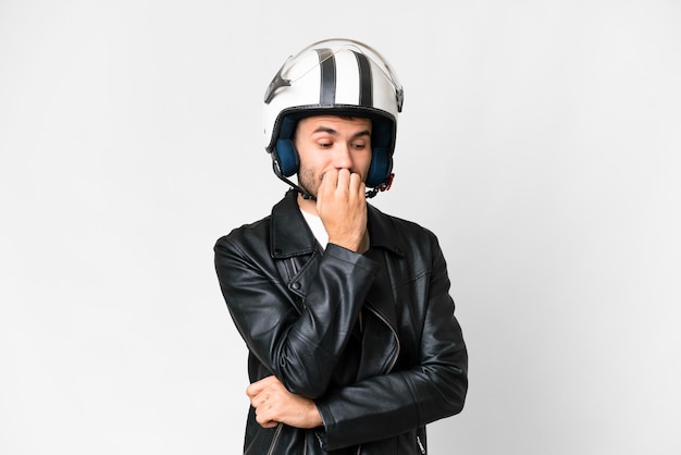 Giovane uomo caucasico con un casco da motociclista su sfondo bianco isolato con dubbi