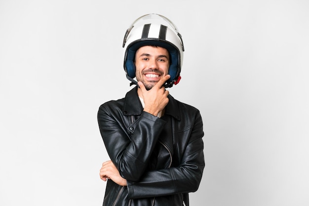 Giovane uomo caucasico con un casco da motociclista su sfondo bianco isolato felice e sorridente