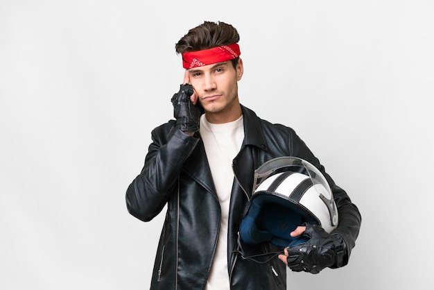 Giovane uomo caucasico con un casco da motociclista su sfondo bianco isolato pensando un'idea