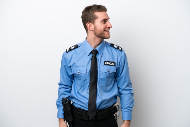 Giovane uomo caucasico della polizia isolato su sfondo bianco guardando il lato