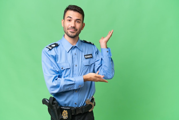 Giovane uomo caucasico della polizia su sfondo isolato che estende le mani di lato per invitare a venire