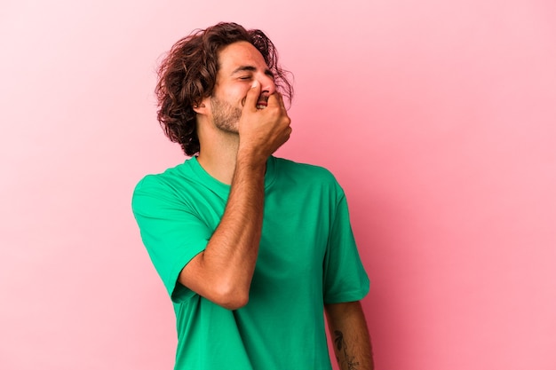 Giovane uomo caucasico isolato su bakcground rosa che ride felice, spensierata, emozione naturale.