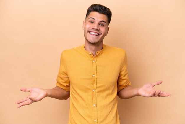 Giovane uomo caucasico isolato su sfondo beige felice e sorridente