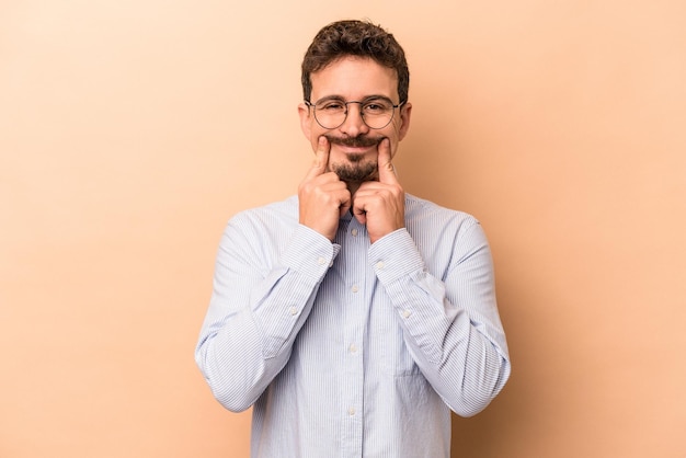 Giovane uomo caucasico isolato su sfondo beige in dubbio tra due opzioni.