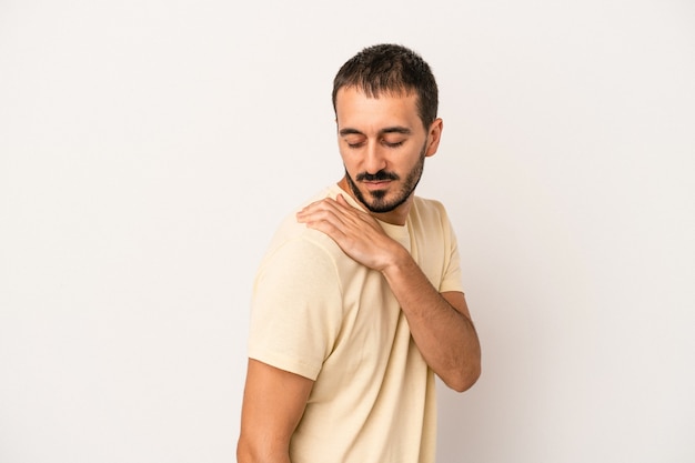 Giovane uomo caucasico isolato su sfondo bianco che ha un dolore alla spalla.