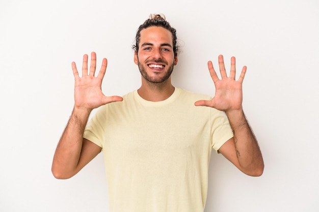 Giovane uomo caucasico isolato su sfondo bianco che mostra il numero dieci con le mani.