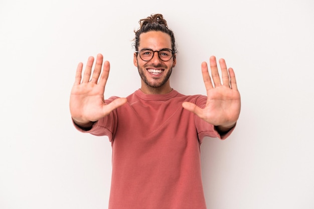 Giovane uomo caucasico isolato su sfondo bianco che mostra il numero dieci con le mani.