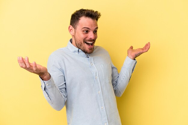 Giovane uomo caucasico isolato su sfondo giallo gioioso ridendo molto. Concetto di felicità.