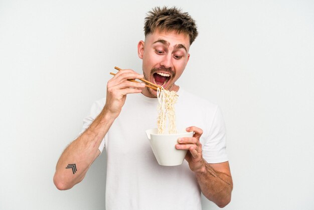 Giovane uomo caucasico mangiare tagliatelle isolati su sfondo bianco