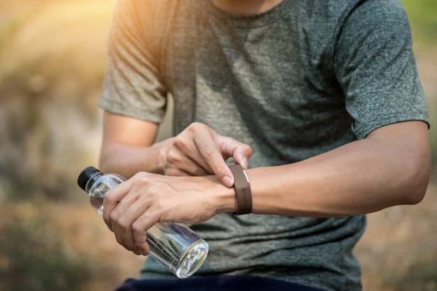 Giovane uomo che controlla tempo sul suo orologio sportivo