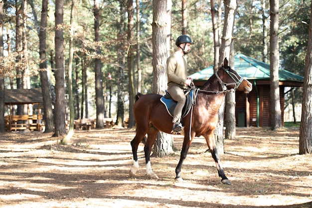 Giovane uomo che indossa casco e cavallo