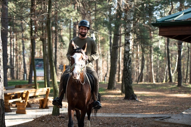 Giovane uomo che indossa casco e cavallo