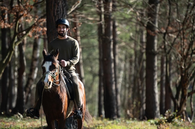 Giovane uomo che indossa casco e cavallo