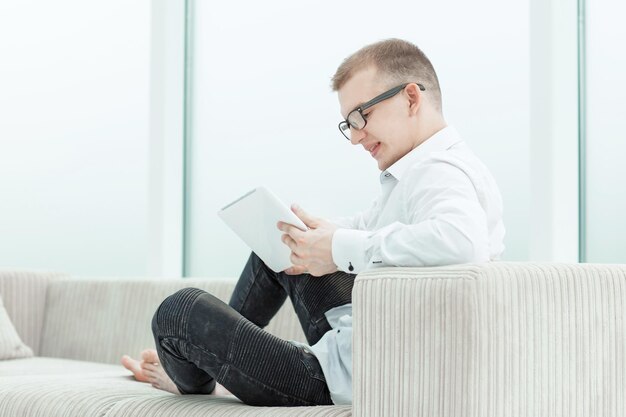 Giovane uomo che sfoglia i file multimediali sul suo tablet.foto con copia spazio