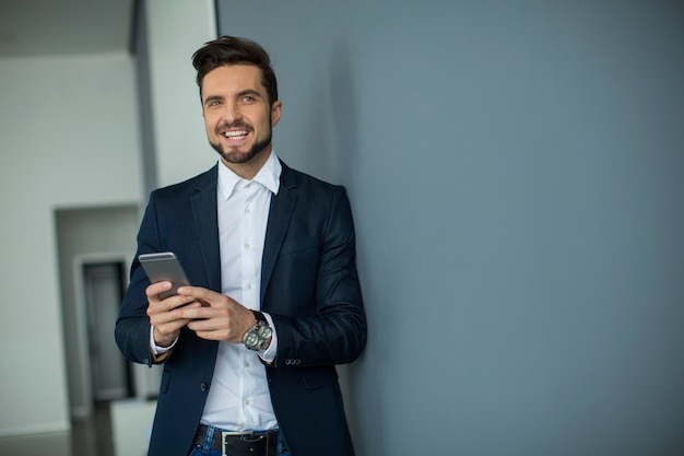 Giovane uomo con il cellulare in ufficio