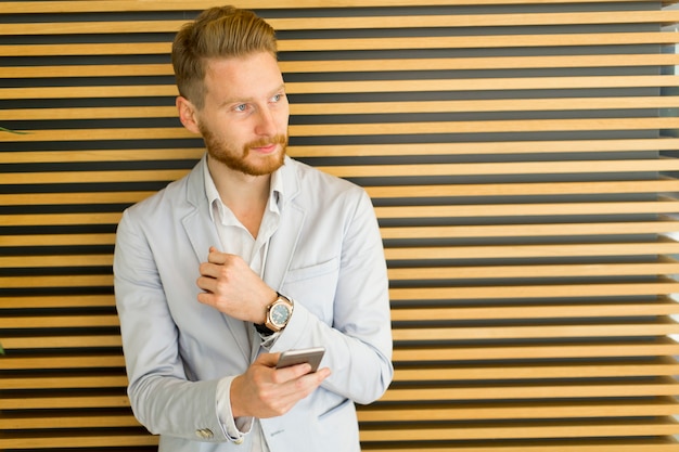 Giovane uomo con il cellulare in ufficio