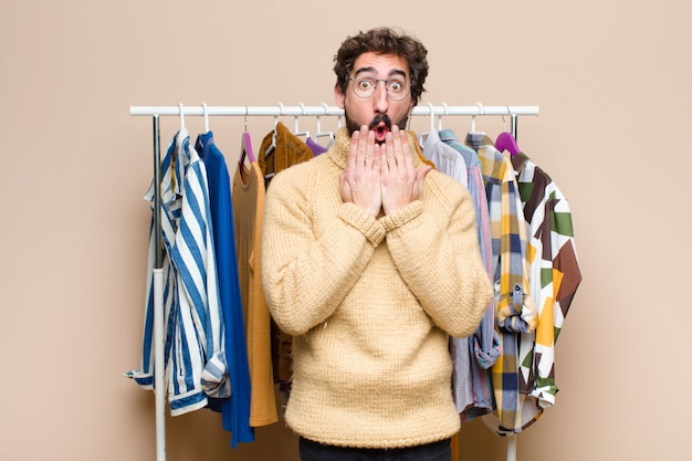 Giovane uomo con la barba fresca con vestiti sulla parete piatta