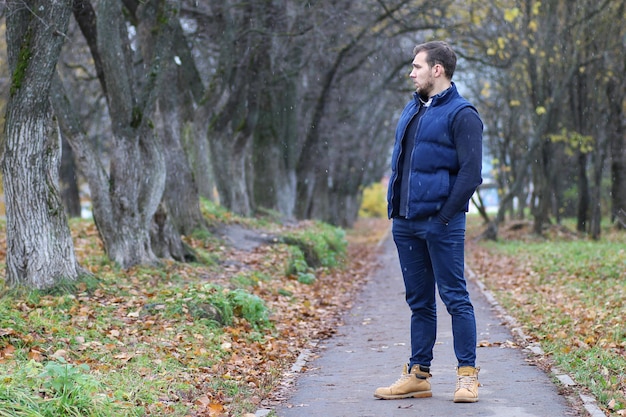 Giovane uomo con la barba in un parco autunnale