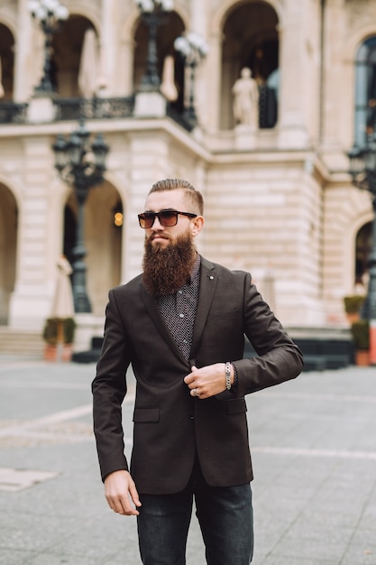 Giovane uomo con la barba lunga sulla strada della città.