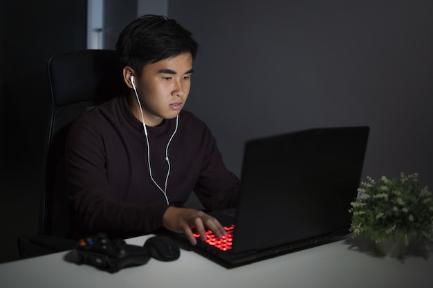 giovane uomo con laptop sul tavolo di notte