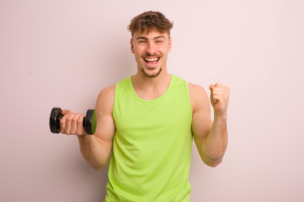 Giovane uomo cool che si sente scioccato ridendo e celebrando il concetto di fitness di successo