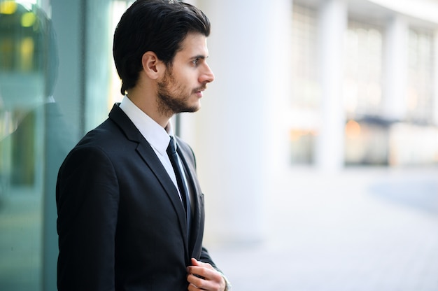 Giovane uomo d'affari all'aperto in un'espressione seria che regola il suo sguardo