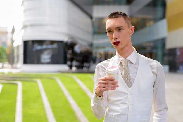 Giovane uomo d'affari androgino che beve caffè