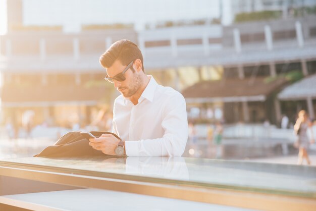 giovane uomo d&#39;affari bello utilizzando smartphone